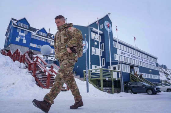 A Danish soldier walks in front of the Arctic Command while wearing his military uniform.