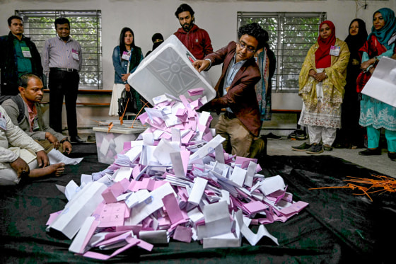 A room with a group of electoral officials opening a ballot box in Bangladesh.