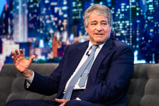 Leon Black speaks while seated on a couch