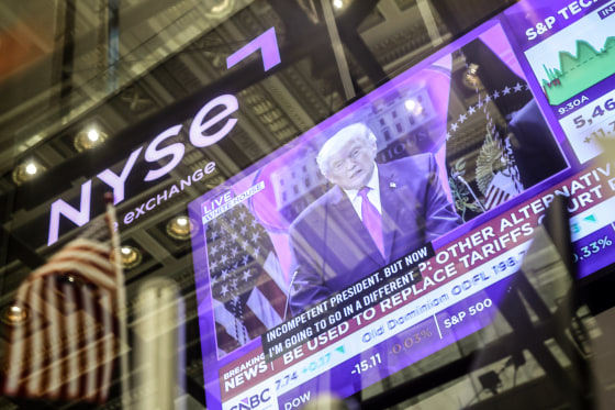 Donald Trump appears on a TV screen, obscured by window reflections. The NYSE logo is visible in the background.