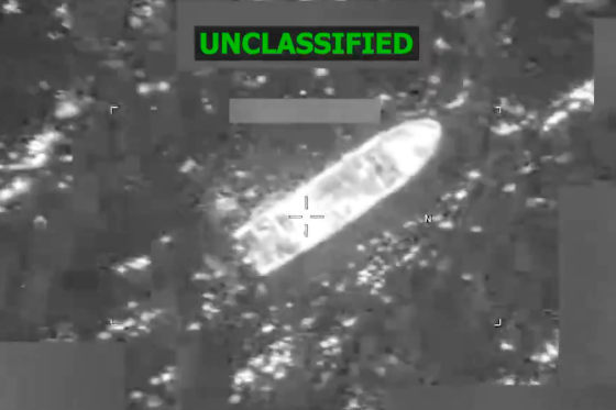 A grainy, black and white satellite image shows the rough outline of a boat in the water.