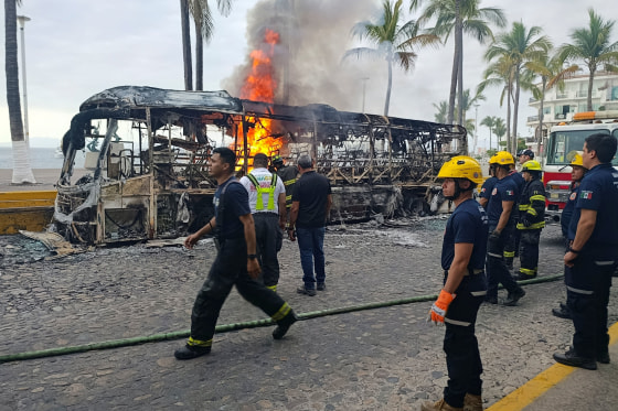 Firefighters work to extinguish flames from buses allegedly set on fire by members of organized crime in Puerto Vallarta, Mexico, on Feb. 22, 2026. 