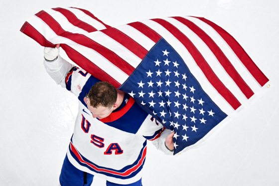 Aerial view of Brady Tkachuk holding an American flag in the air