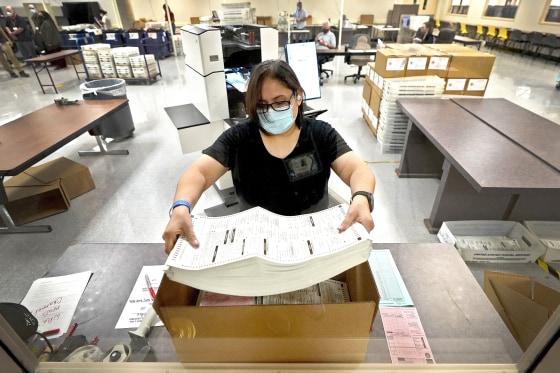 Image: An election official counts ballots inside the Maricopa County Recorder's Office in Phoenix