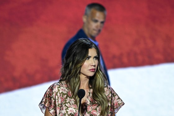 Kristi Noem takes part in a sound check as Corey Lewandowski looks on.