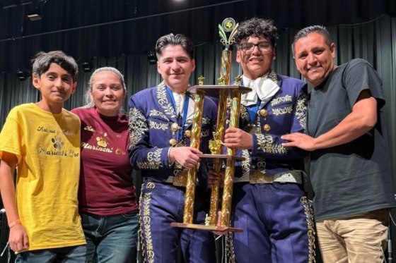 Antonio, third from left, and Caleb Gámez-Cuéllar, hold a trophy surrounded by their brother, mother and father.