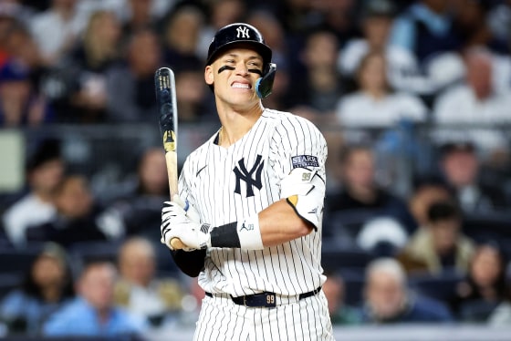 Aaron Judge holds a baseball bat on the field