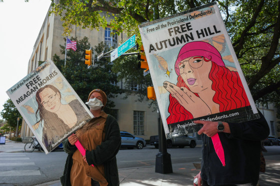 People hold signs in the street.