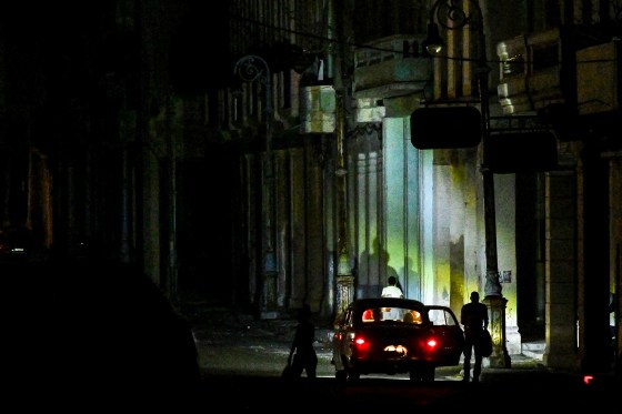 A car parks on a dark street during a blackout.