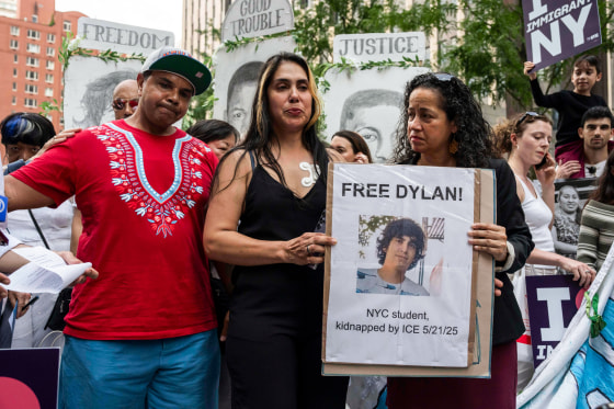 Raiza, center, holds a sign with another woman showing a picture of Dylan Lopez Contreras