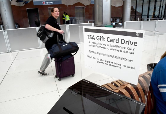 A traveler walks past a gift card donation box for TSA officers