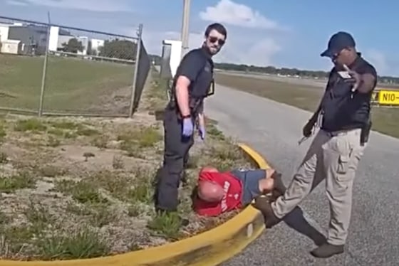 Bryan J. Parker lies on the ground after his arrest.