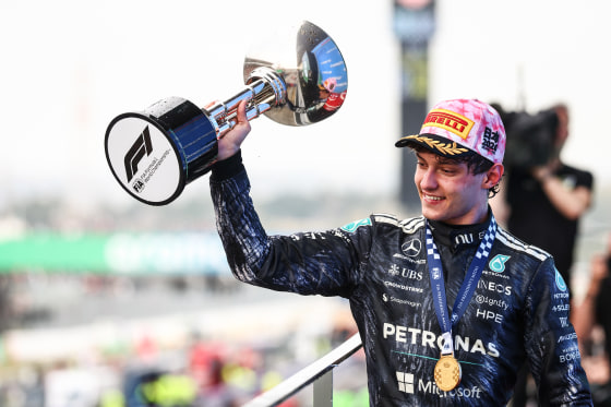 Kimi Antonelli holds up a silver trophy outside