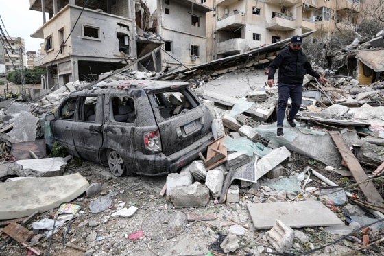 A man walks on the rubble of a destroyed building