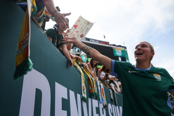 Delanie Sheehan of Denver Summit FC signs autographs in the stands outside