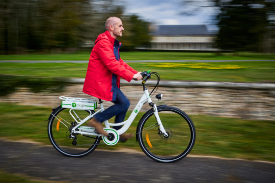 Adrien Lelievre rides on a Pi-Pop electric bike outside, motion shot