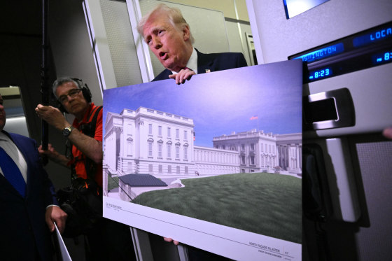 Donald Trump holds a rendering of the East Wing modernization as he speaks to reporters aboard Air Force One en route to Joint Base Andrews, Maryland, on March 29, 2026.