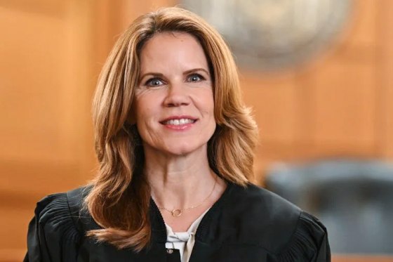 Chris Taylor smiles for a portrait in her judge's robe