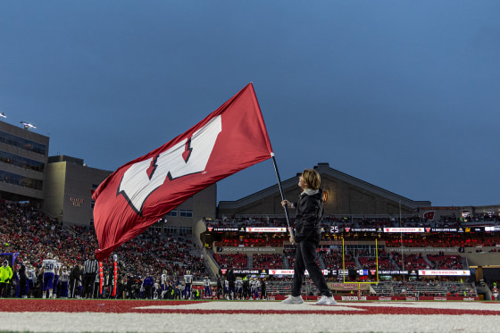 A University of Wisconsin cheerleader waves the school's during a game in 2025.