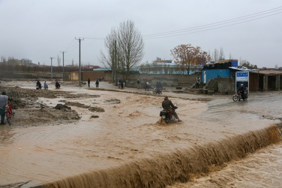 An Afghan motorist wades across a flooded road during rainfall in Ghazni Province on April 1.