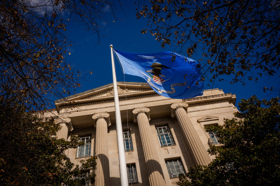 A blue flag flying in front of the DOJ headquarters in Washington.