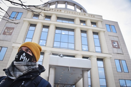 A demonstrator wearing a mask with the logo of Russia's rights group Memorial stands outside the Moscow City Court in 2021.