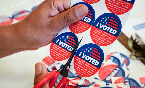 Close up on a sheet of "I Voted" stickers being cut on a table