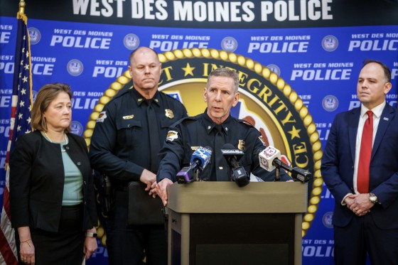 A police officer holds a lectern with both hands during a press briefing