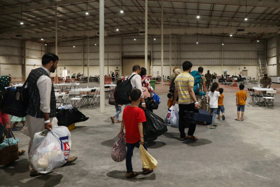 In this handout image Afghan Special Immigrants walk through the in-processing building