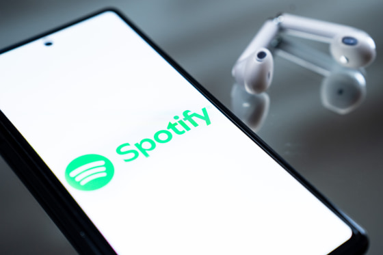 The Spotify logo appears on a smartphone screen.