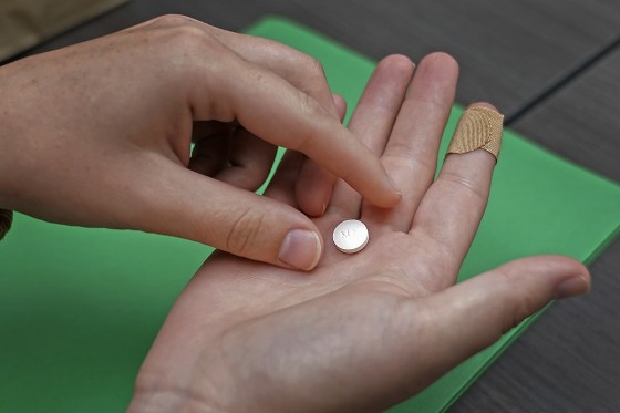 A patient prepares to take the first of two combination pills, mifepristone.