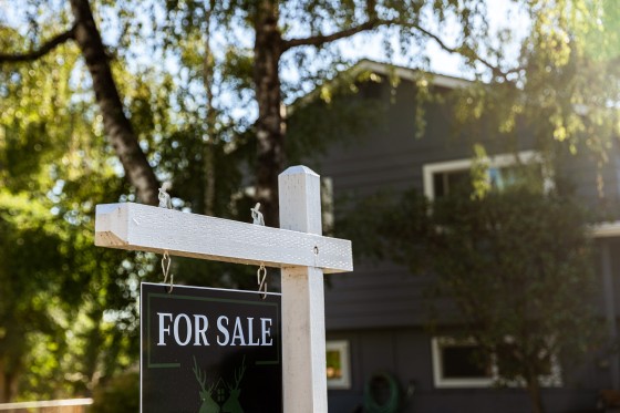 Image: Image of a real estate for sale sign posted in front of a residential home