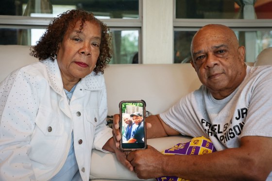 Cynthia and Nelson Wells, Sr. with a photo of Nelson, Sr. and their son Nelson Wells, Jr., who’s been imprisoned in China since 2014, in their home in Haughton, La. 