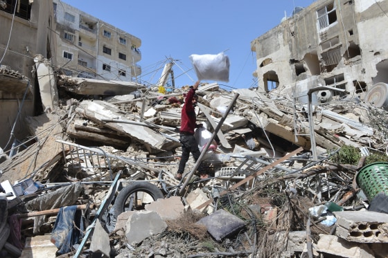 A man collects his family's belongings from the rubble of a building destroyed in an Israeli airstrike the previous day in the southern village of Maarakeh, Lebanon.
