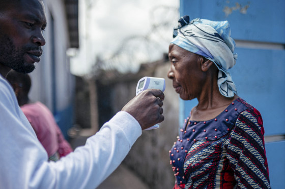 A staff member of the CBCA Virunga Hospital checks a visitor's temperature
