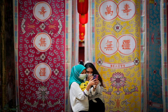 Two girls look at a mobile phone in downtown Kuala Lumpur, Malaysia, in 2021.