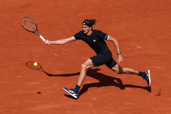 Alexander Zverev prepares to hit a tennis ball while running on a tennis court