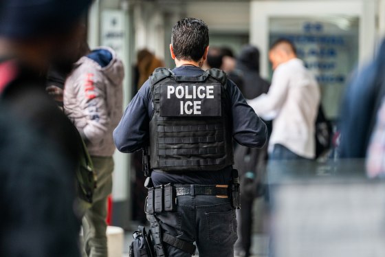 An ICE agent walks through a crowd