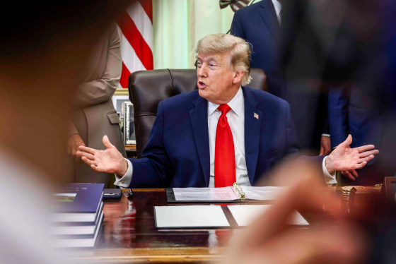 Donald Trump speaks while seated at a desk in the oval office
