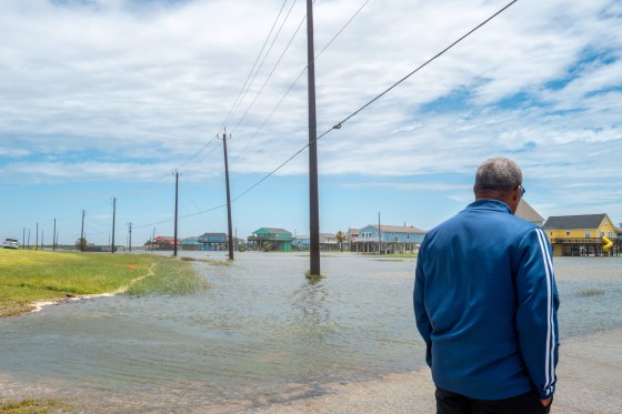 A person looks out towards a flooded neighborhood after Tropical Storm Arthur made landfall.