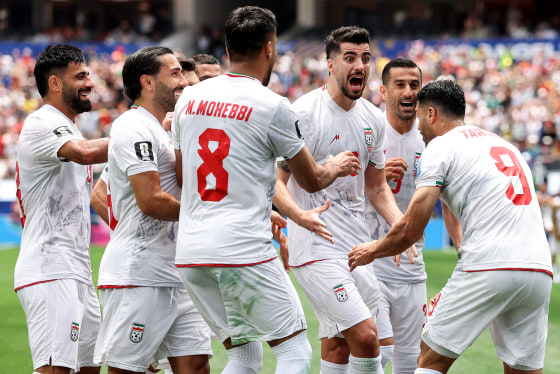 Iranian team members celebrate in a huddle