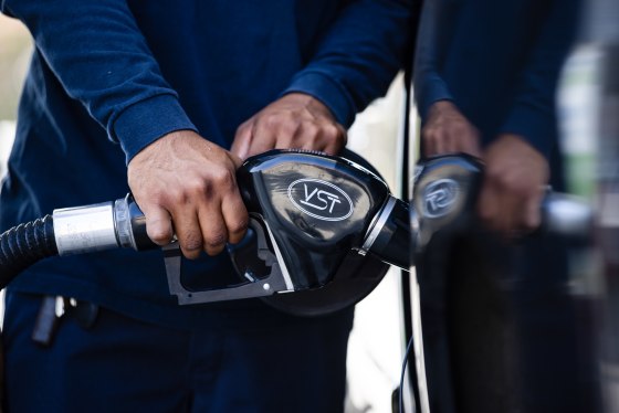 Close up of hands holding a gas pump inserted into a car