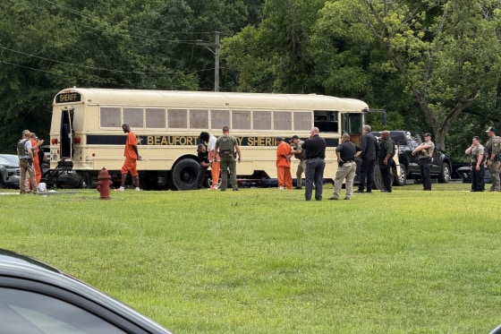 In this photo provided by the North Carolina State Bureau of Investigation, law enforcement officers loads inmates for transport.