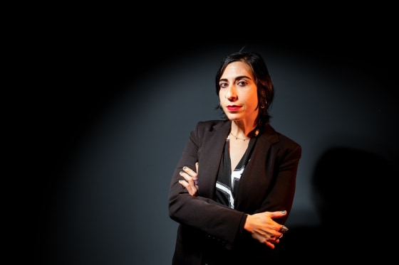Tamar Shirinian poses against a black background with her arms crossed