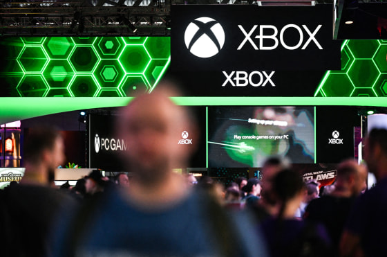 People walk around an exhibition floor, Xbobx signage is above them
