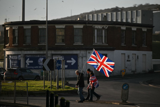 A group of people appears to be crossing the street while holding the Union Jack flag.