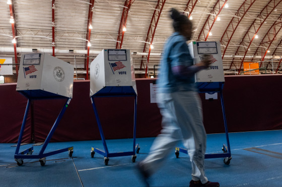 A woman walks past polling vote tables.