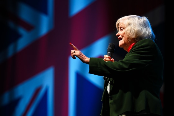 Ann Widdecombe, Immigration and Justice spokeswoman for Reform UK, with a mic and a UK flag in the background, at Westpoint Arena during the South West conference.