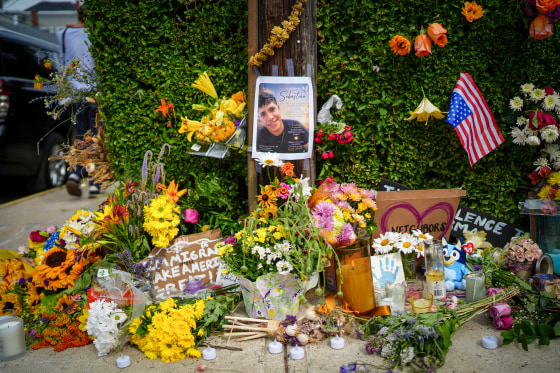 A makeshift memorial for Johan Sebastián Durán Guerrero with flowers, flags, signs and photos.
