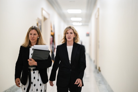 Kathryn Ruemmler, center, walks next to another woman down a hallway